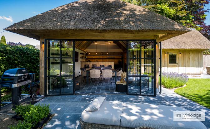 Pool house de estilo rústico con tejado de paja y ventanales de acero Pool house de estilo rústico con tejado de paja y ventanales de acero