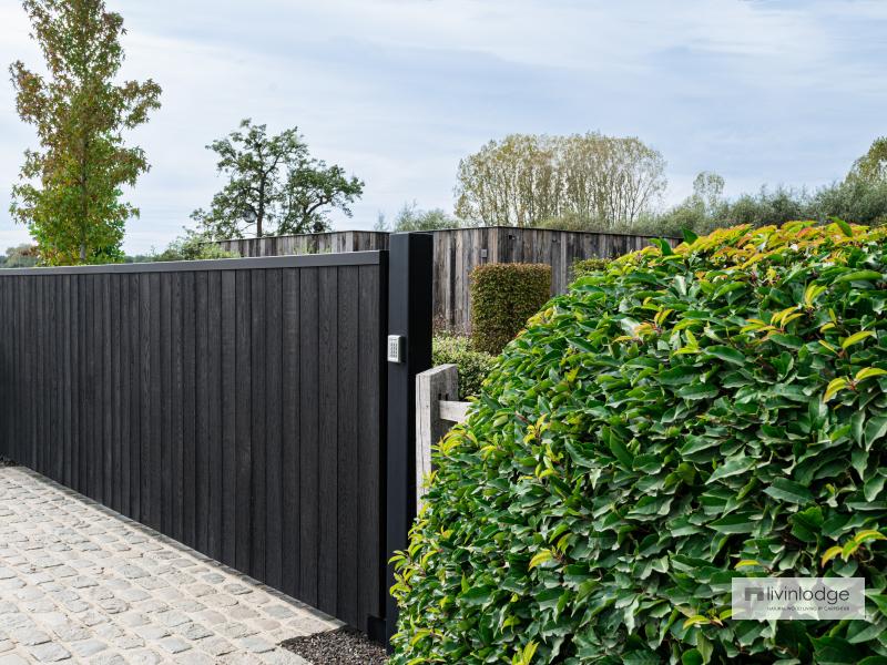Mooie harmonie tussen zwarte poort en groene omgeving Mooie harmonie tussen zwarte poort en groene omgeving