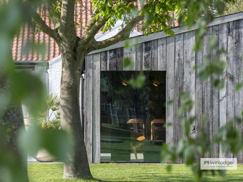 Zijaanzicht van houten bijgebouw met barnwood gevelbekleding Zijaanzicht van houten bijgebouw met barnwood gevelbekleding