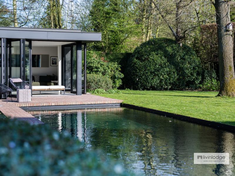 Moderne poolhouse als oase van rust aan rand zwembad Moderne poolhouse als oase van rust aan rand zwembad