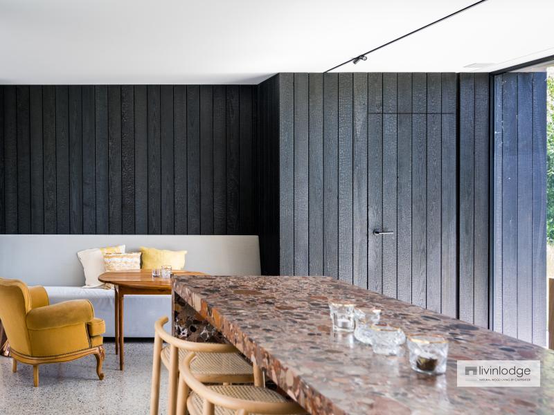 Moderne aanbouw met zwart-wit interieur en warme okeraccenten Moderne aanbouw met zwart-wit interieur en warme okeraccenten