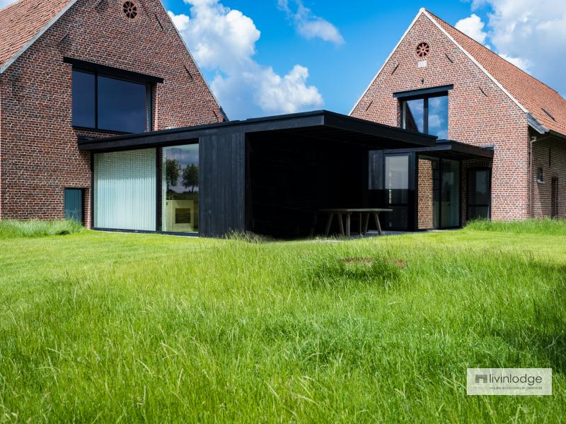 Zwarte moderne aanbouw in houtskelet Zwarte moderne aanbouw in houtskelet