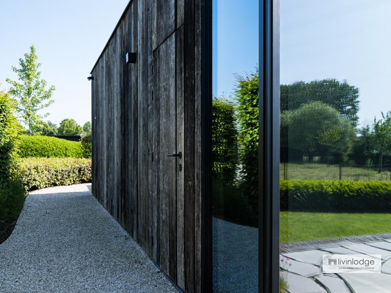 Barnwood deur mooi geïntegreerd in gevel houten bijgebouw Barnwood deur mooi geïntegreerd in gevel houten bijgebouw