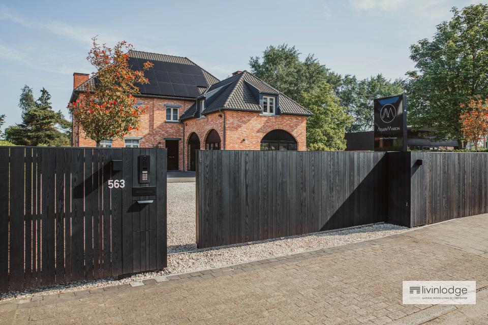 Moderne houten schuifpoort met bijpassende omheining Moderne houten schuifpoort met bijpassende omheining