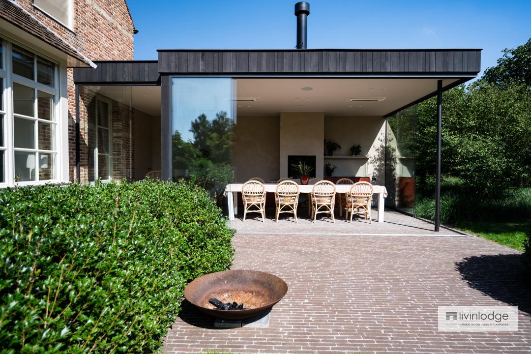 Moderne houten tuinkamer met open haard aangebouwd aan woning Moderne houten tuinkamer met open haard aangebouwd aan woning